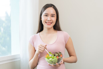 Diet concept, happy smile asian young woman use fork to prick lettuce, fresh vegetable or green...