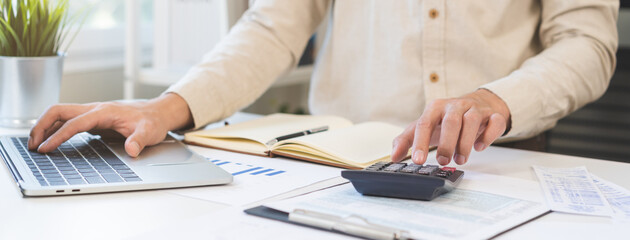 Account finance, asian young business man hand using calculator, laptop computer for calculate...