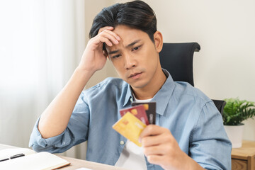 Debt and financial concept, stressed asian young man, male have a headache while sitting calculate...