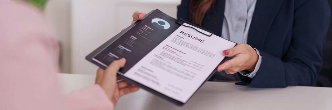 Human resources professional receives job applicant resume for new career opportunity in modern office setting
