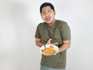 Asian handsome man holding noodles and having stomachache.  eating lunch concept. isolated white...