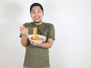 Handsome Asian man enjoying noodles with a fork. Eating lunch concept. Isolated white background