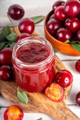 Cherry plum jam in small jar. Homemade autumn red cherry plum marmalade confiture with fresh...