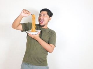 Handsome Asian man holding noodles with a fork while shouting and getting angry. Eating lunch...