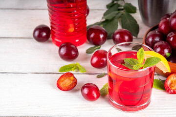 Summer iced refreshment drink, cherry plum lemonade or mojito cocktail in jug and glass,  on a...