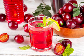 Summer iced refreshment drink, cherry plum lemonade or mojito cocktail in jug and glass,  on a...