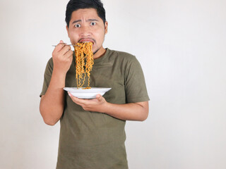 Handsome Asian man eating noodles with a worried and scared expression. Eating lunch concept....