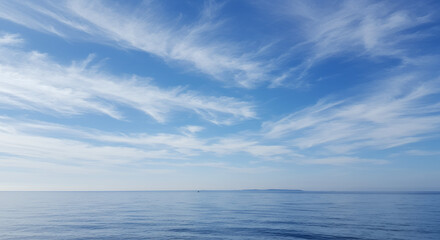 Serene Ocean View with Cirrus Clouds: A tranquil seascape featuring clear blue sky, calm water, and distant island.
