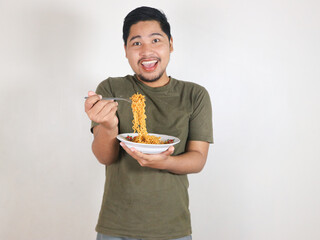 happy Handsome Asian man enjoying fried noodles with a fork. Eating lunch concept. Isolated white background