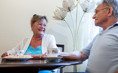Retirement: Socialising Seniors. A British senior couple enjoying a break over a cup of tea and...