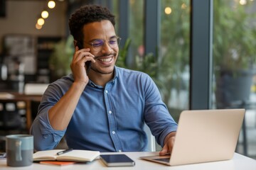 Man on phone with laptop and notebook african american