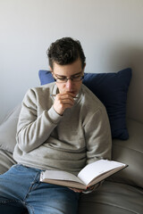 Young boy sitting on the bed thinking what to write in a notebook
