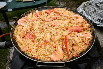 Cooking paella with seafood and lobster outdoors