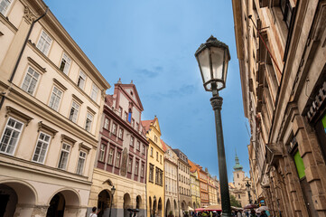 Prague,Czech Republic, August 5, 2023. The food market and St. Havel's Church in the background. Beautiful medieval houses with colorful facades overlook the street. People wander through the market.