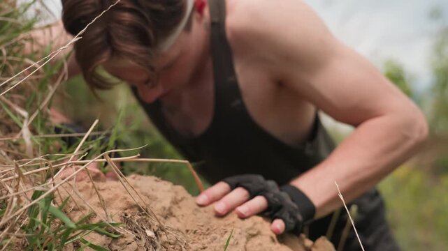 trooper marching on sandy mound focusing on boot plunging into loose sand and grass stems with close up of textured soil stones and gloved hand grip hinting at military tension in wilderness terrain