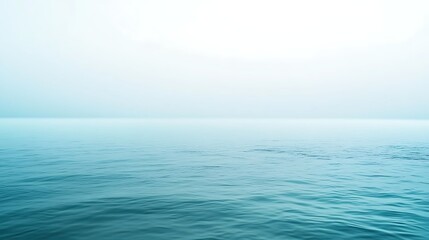 Obraz premium Calm turquoise sea water meets the horizon with soft white sky background image