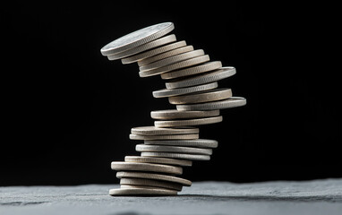 Wobbly stacked coins financial instability economy risk investment money