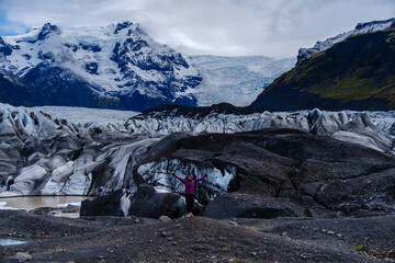 An adventurer celebrates amidst the breathtaking Svinafellsjokull Glacier, surrounded by jagged ice...