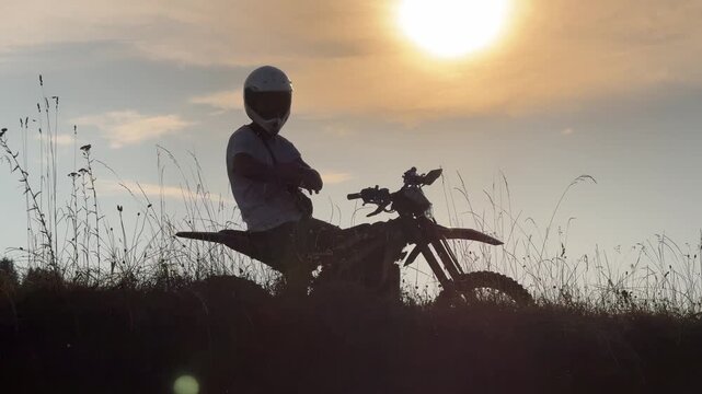 Man is sitting on a dirt bike in a field