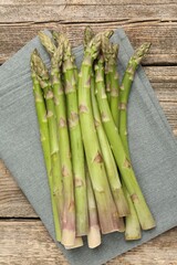 Fresh raw asparagus spears on wooden table, top view