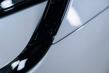 A view of the protected paintwork of a silver electric limousine in a professional detailing studio...