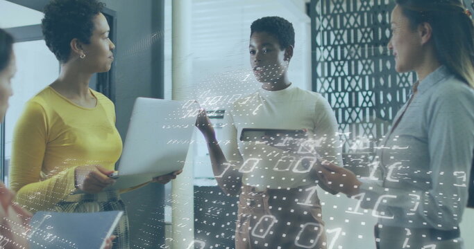 Four women reviewing roadmap in office, with laptop tablet smartphone, display screen code overlay