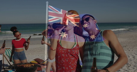 Friends cooking skewers on barbecue grill at sandy beach, with beer bottles and Union Jack flag