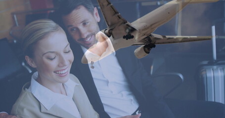 Executives in suits using tablet leaning in airport lounge, with suitcase, airplane, copy space