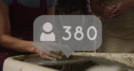 Molding clay vessel with adult man's wet hands at pottery workshop, with user icon showing 380