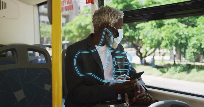 Holding smartphone masked man in blazer gazing out window on bus, with glowing thumbs-up overlay