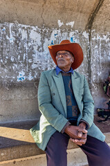 Africa village, single elderly african traveler man waiting in a bus station, taking a trip,...