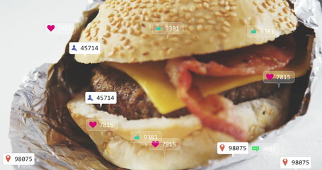 Bacon cheeseburger sitting in sesame-seed bun foil wrap on studio surface, with social media icons