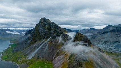 Exploring the stunning landscape of East Iceland, where rocky peaks rise sharply from lush green...