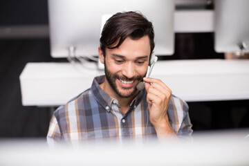Call center headset sitting on white desk among multiple monitors in modern cubicle
