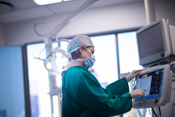 Touchscreen monitor displaying vital signs and receiving adjustments in hospital operating room