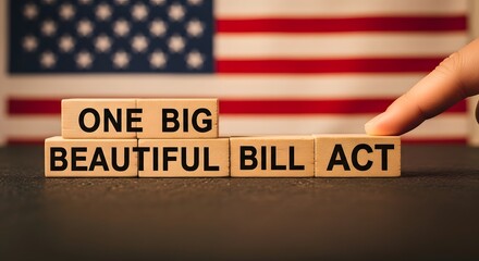 Fingers pointing to wooden blocks spelling one big beautiful bill act