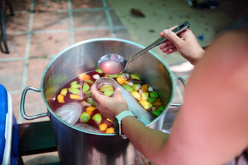 Person Serving Refreshing Homemade Fruit Sangria in an Outdoor Gathering