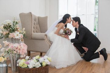 Asian couple getting married, Happy Asian couple in wedding attire and kissing, Bride wearing a...