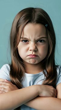 Young girl's expressive pout and crossed arms conveying determination and defiance