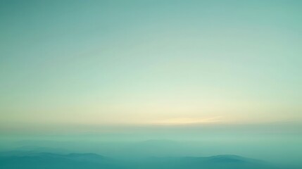 Fototapeta premium Serene mountain landscape with pastel sky and ethereal mist at dawn or dusk. Nature scene