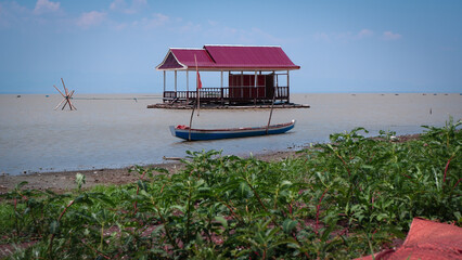 Floating House On Water With Boat And Plants