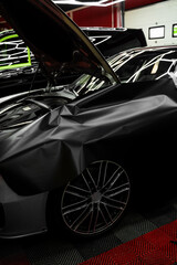 Car Door Panel Wrapping. Process of wrapping car with matte black vinyl and tensioning the...