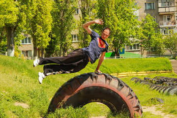 A guy jumps over a large stingray on a green stadium with a trick in parkour style	
