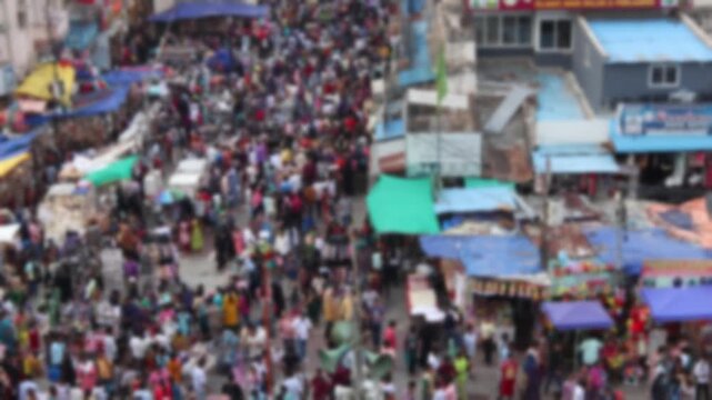 Blurred top view of busy crowded market street full of customers in asian city. Bokeh real time motion video for background.