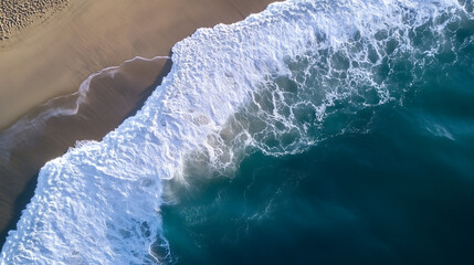 Fototapeta premium Aerial view of a beautiful sandy beach meeting powerful ocean waves, perfect for travel and nature concepts