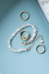 jewelry on a simple background, jewelry aesthetics, jewelry flatlay, gold ring, pearl earrings