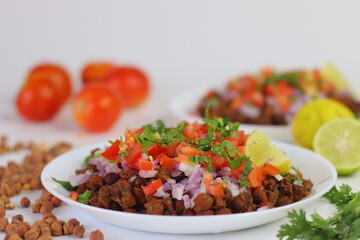 Chana Chat, also known as chickpea salad, served with chopped tomatoes, onions, cilantro, and lime