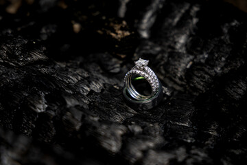 wedding rings with diamonds on burn wooden coals 