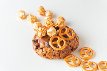Fresh chocolate American chip cookie decorated with salted camel and caramel popcorn on white...