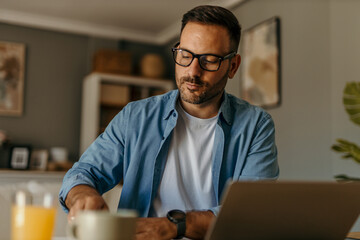 Focused entrepreneur working remotely from home office using laptop